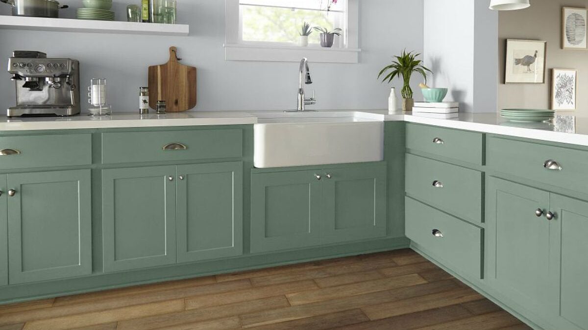 Shaker kitchen cabinets refinished in sage green with a farmhouse sink